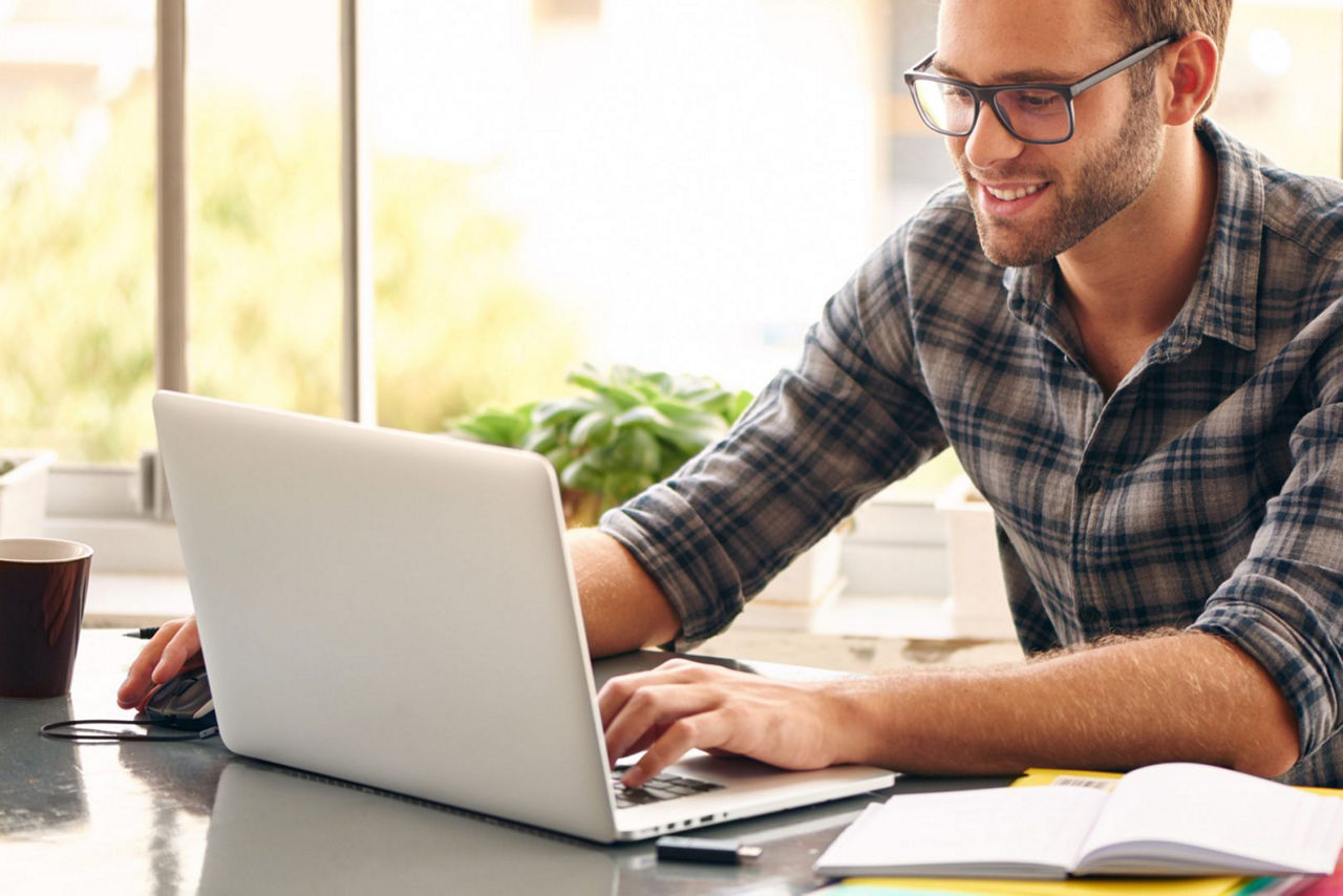 man wearing casual glasses using TeamViewer Remote Control on macbook