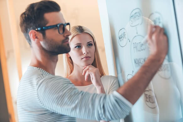 employees demonstrating concepts on a whiteboard