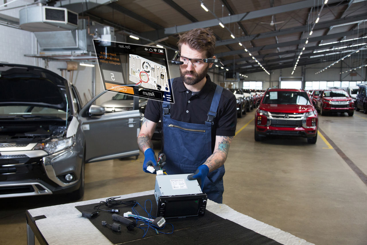 Werknemer in de automobielindustrie die instructiehandleiding controleert met slimme bril