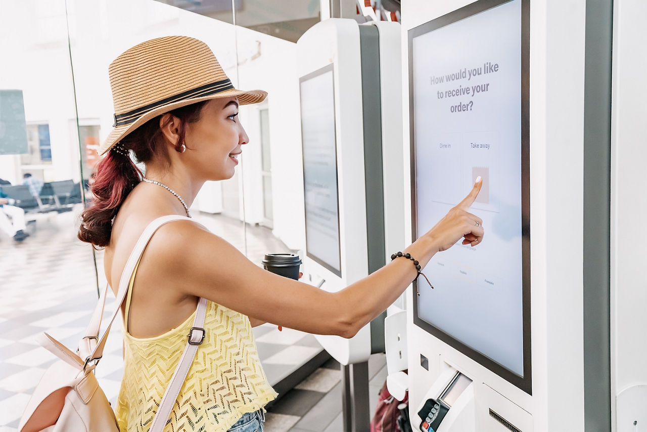 Femme passant une commande sur un système POS avec un grand écran