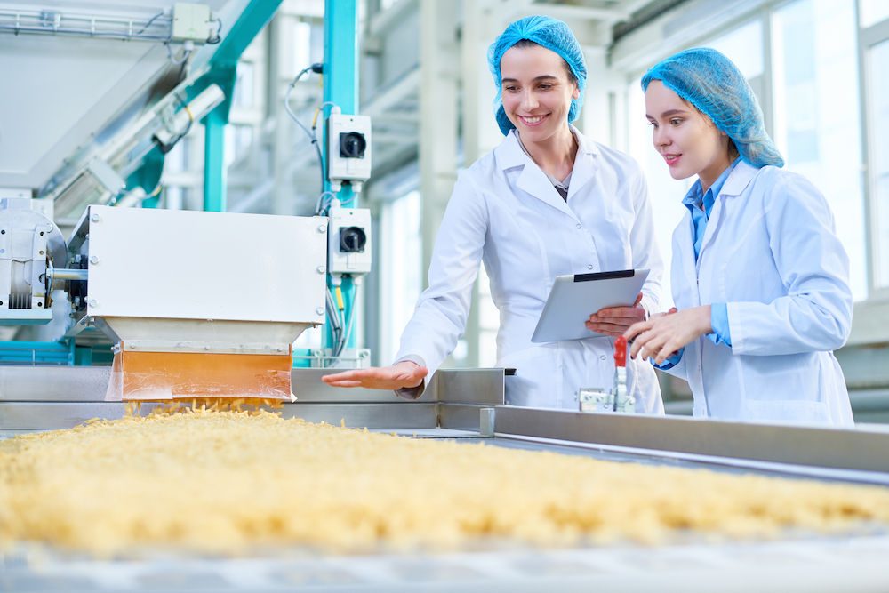 Dois trabalhadores em uma fábrica de processamento de alimentos