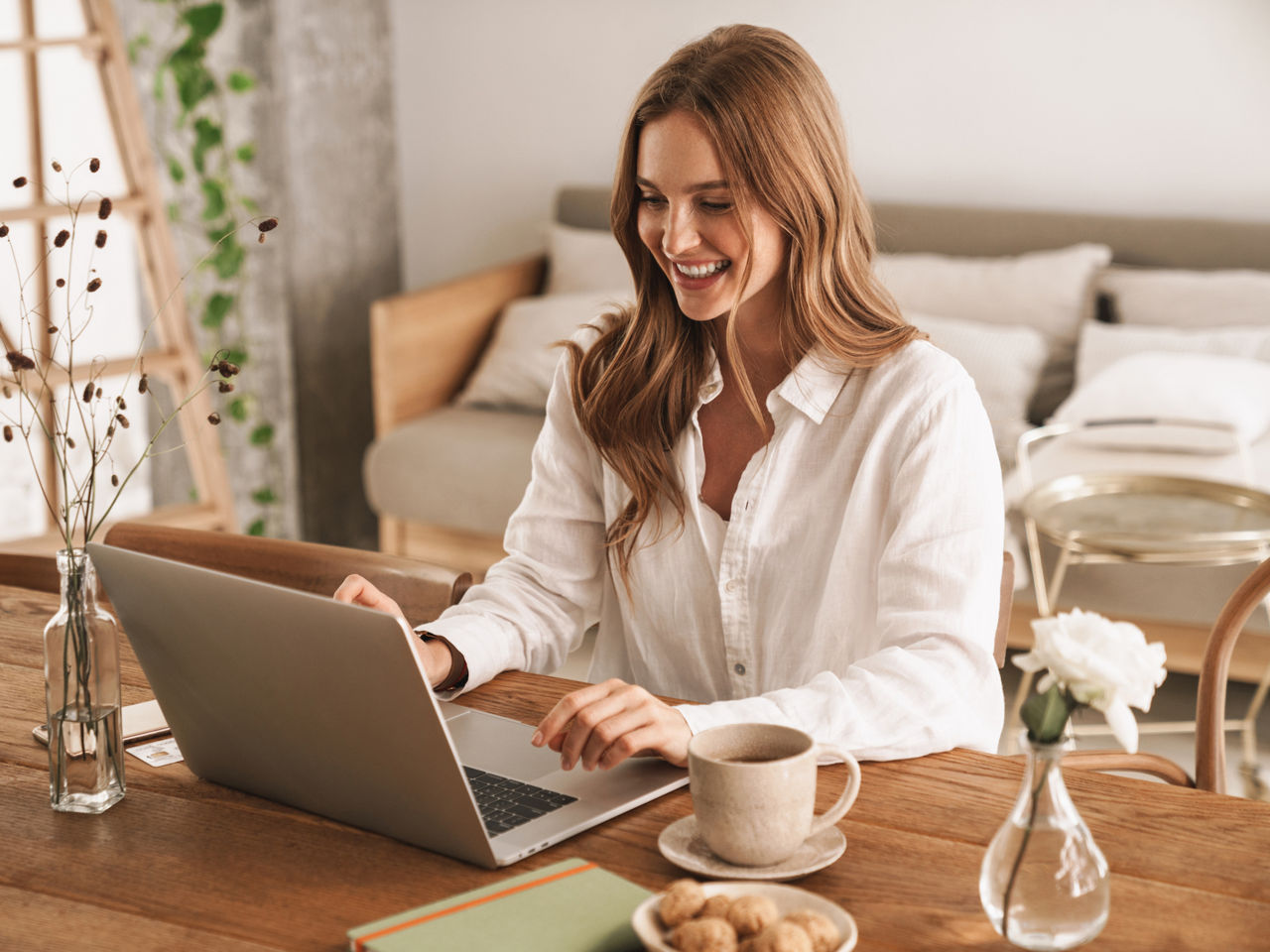 Business woman sits indoors using laptop computer