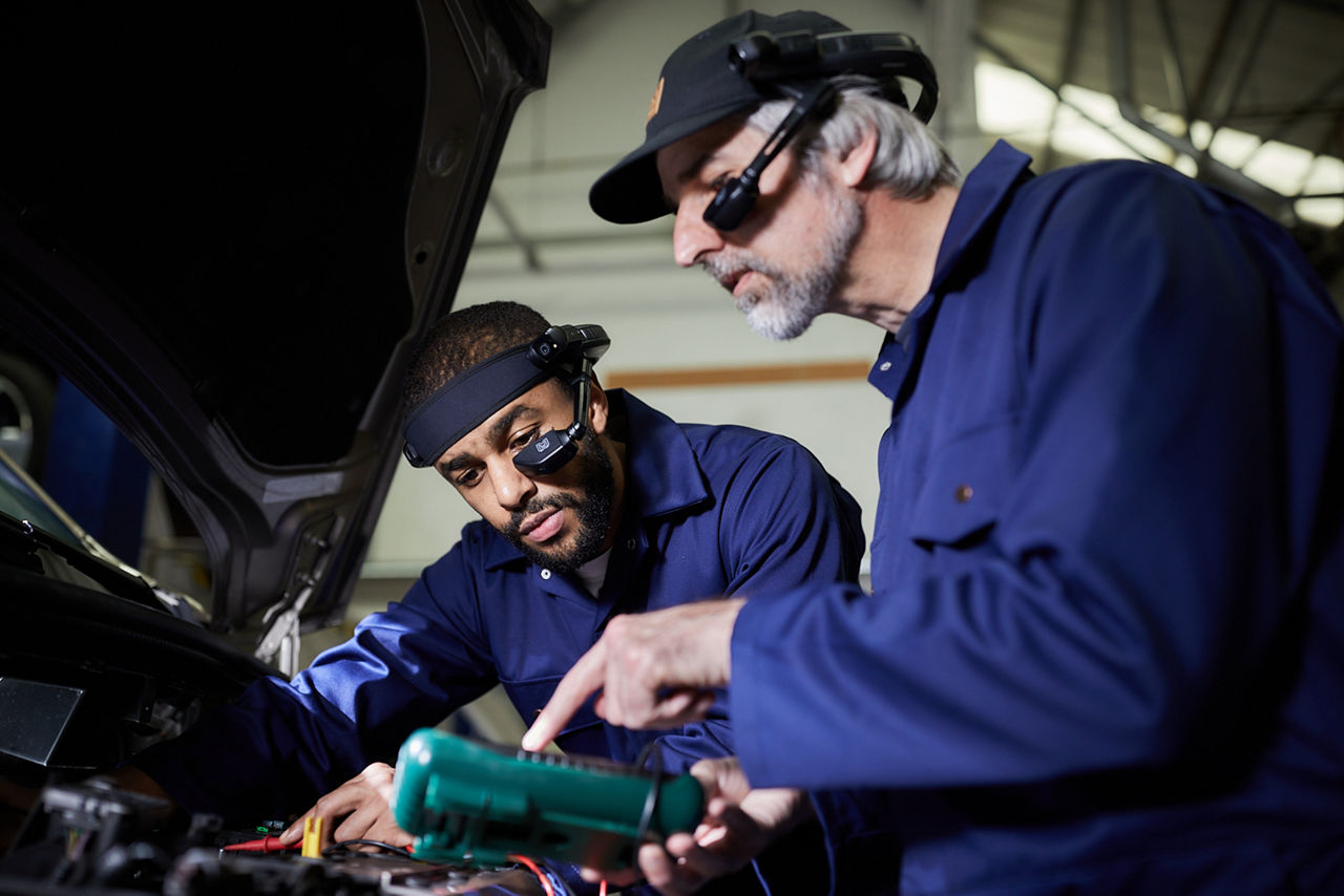 Employé de première ligne effectuant la maintenance d’une voiture grâce à l’assistance par RA