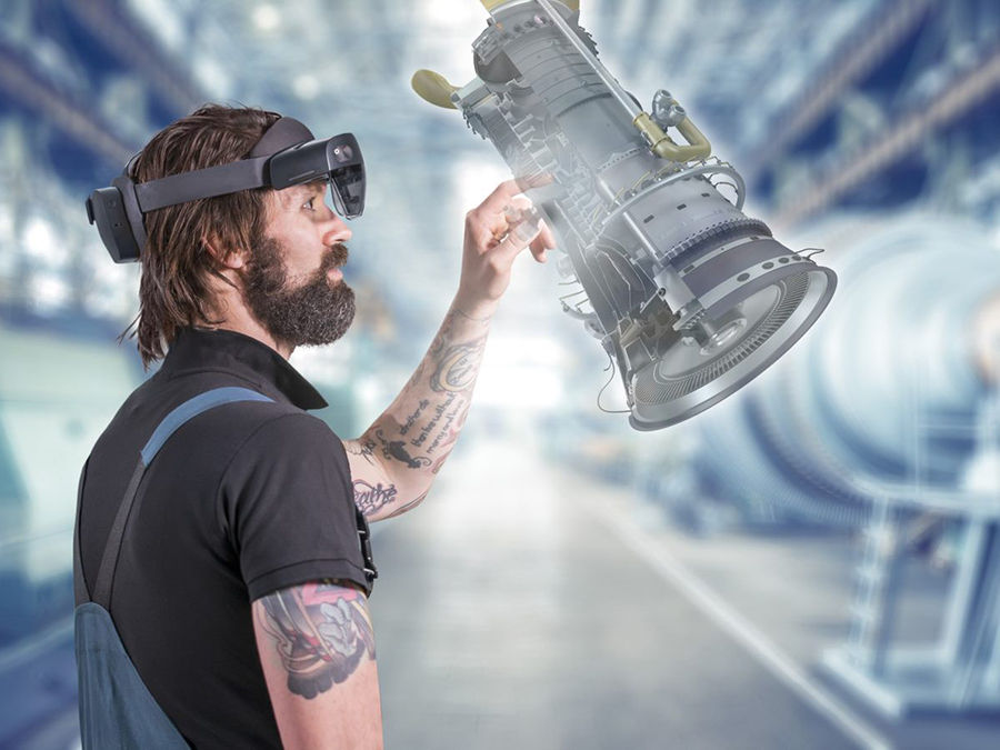 A male engineer inspects a 3D model of a turbine via augmented reality (AR) glasses