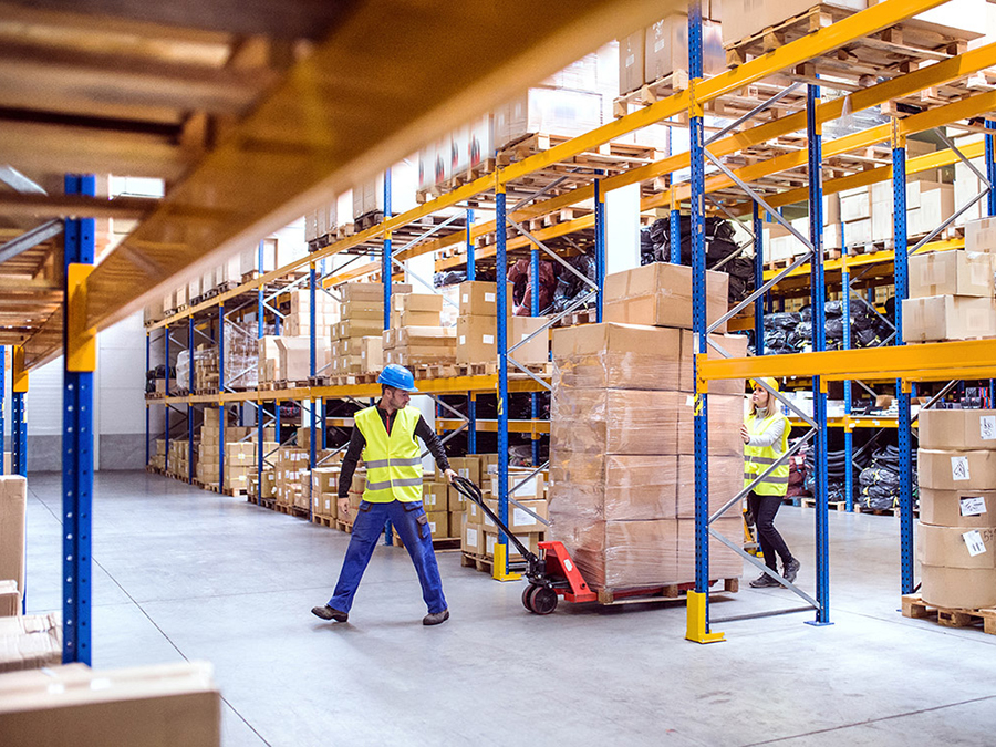 Dos trabajadores moviendo pélets en el almacén