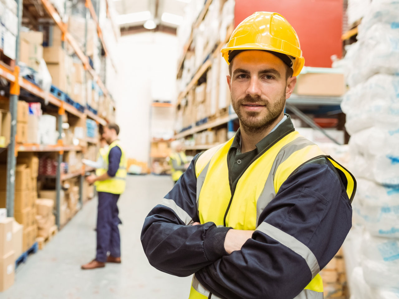 Confident warehouser worker with arms crossed