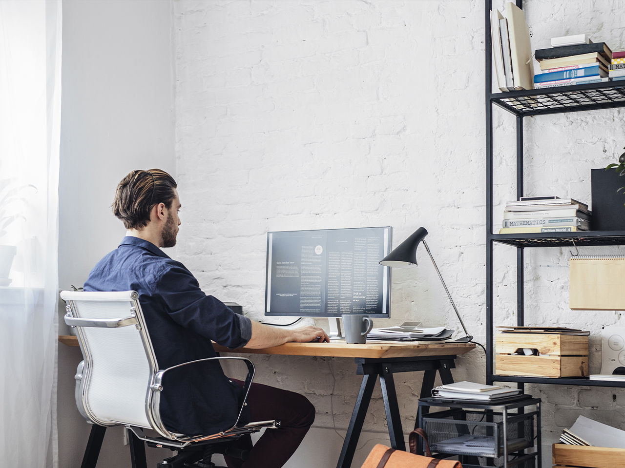 Hombre trabajando en una computadora de escritorio en un entorno híbrido