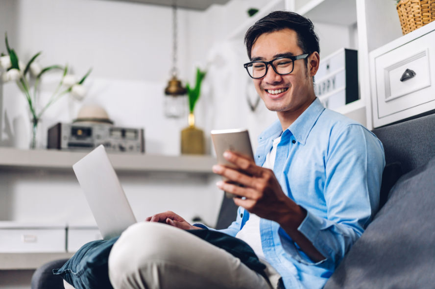 Homme télétravaillant avec un ordinateur portable et un smartphone