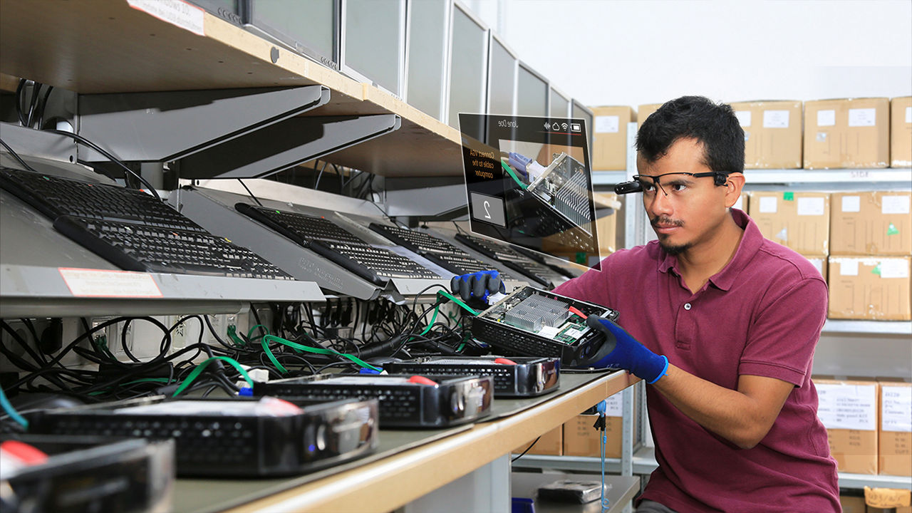 Técnico trabalhando em computadores com assistência em RA