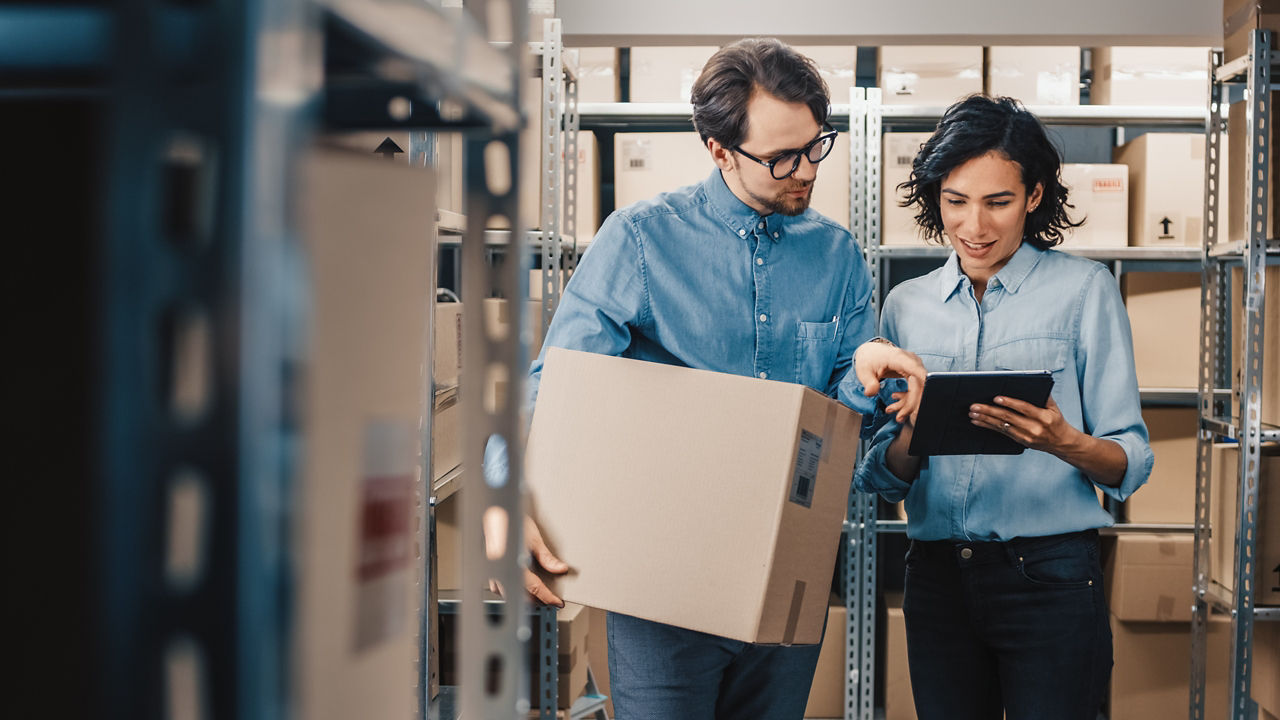 Man and woman picking goods in a warehouse with tablet