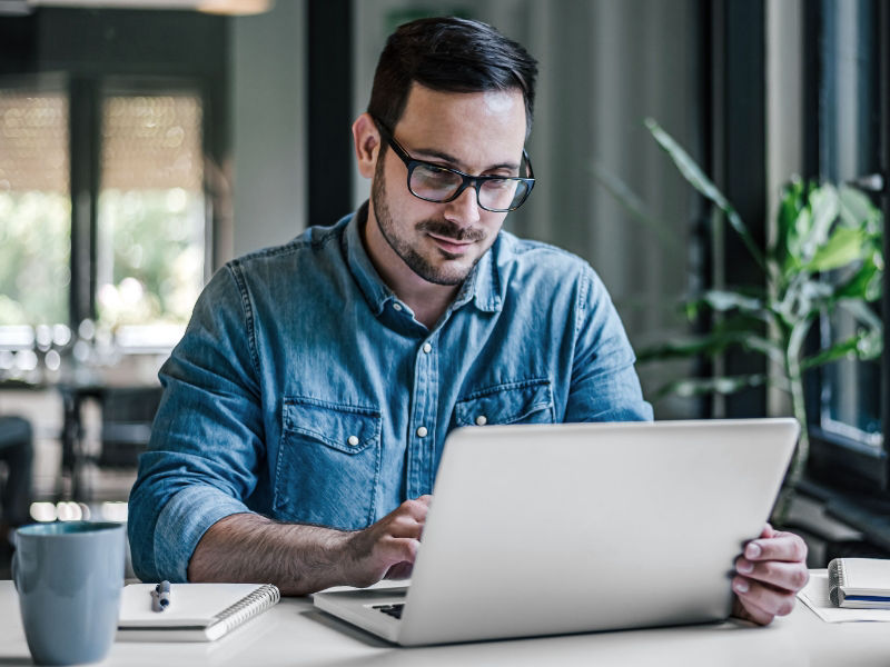 Young man in home office concentrated on laptop