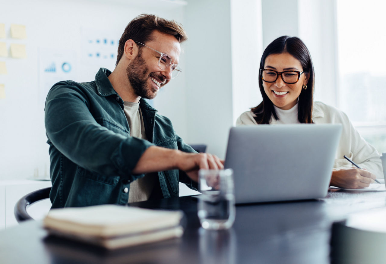 Colegas trabalhando juntos em um laptop