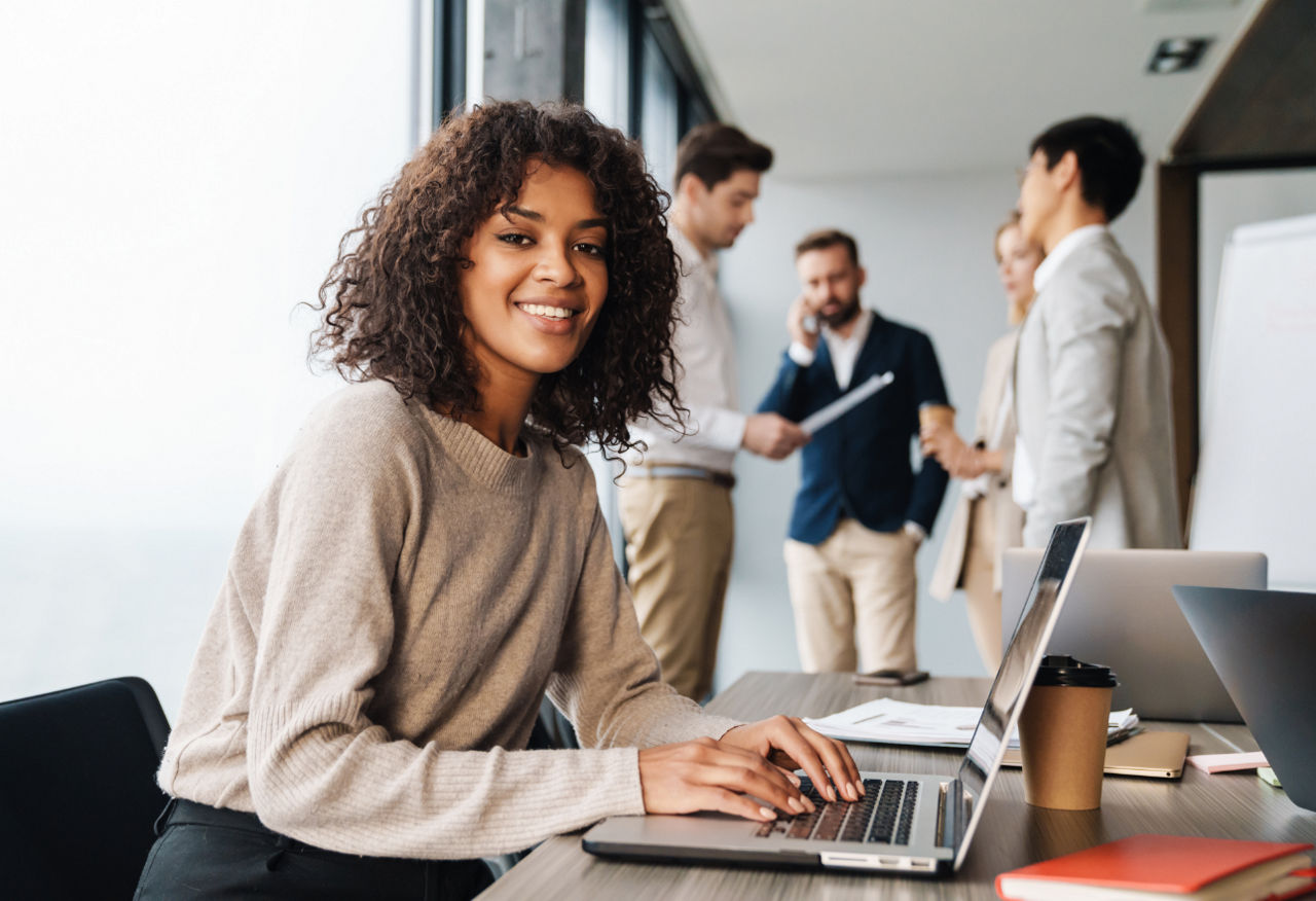 Young woman in office with colleagues in background