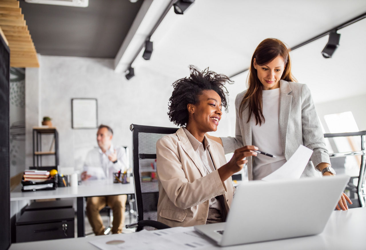 Two women discussing work in office