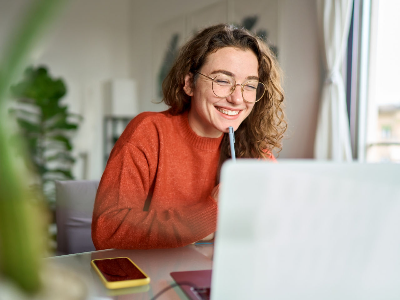 Young woman making notes behind computer