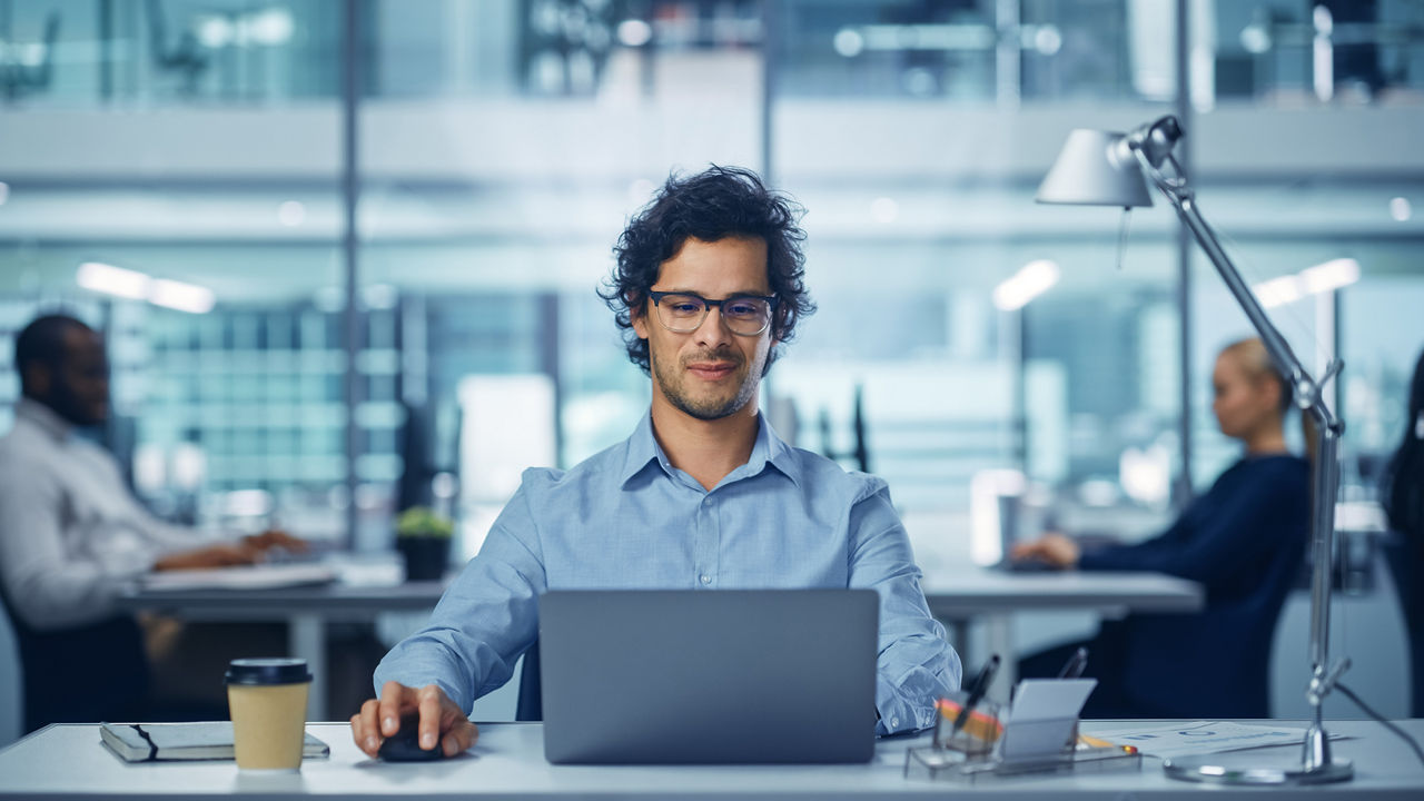 Een zakenman op kantoor werkt op een laptop aan zijn bureau