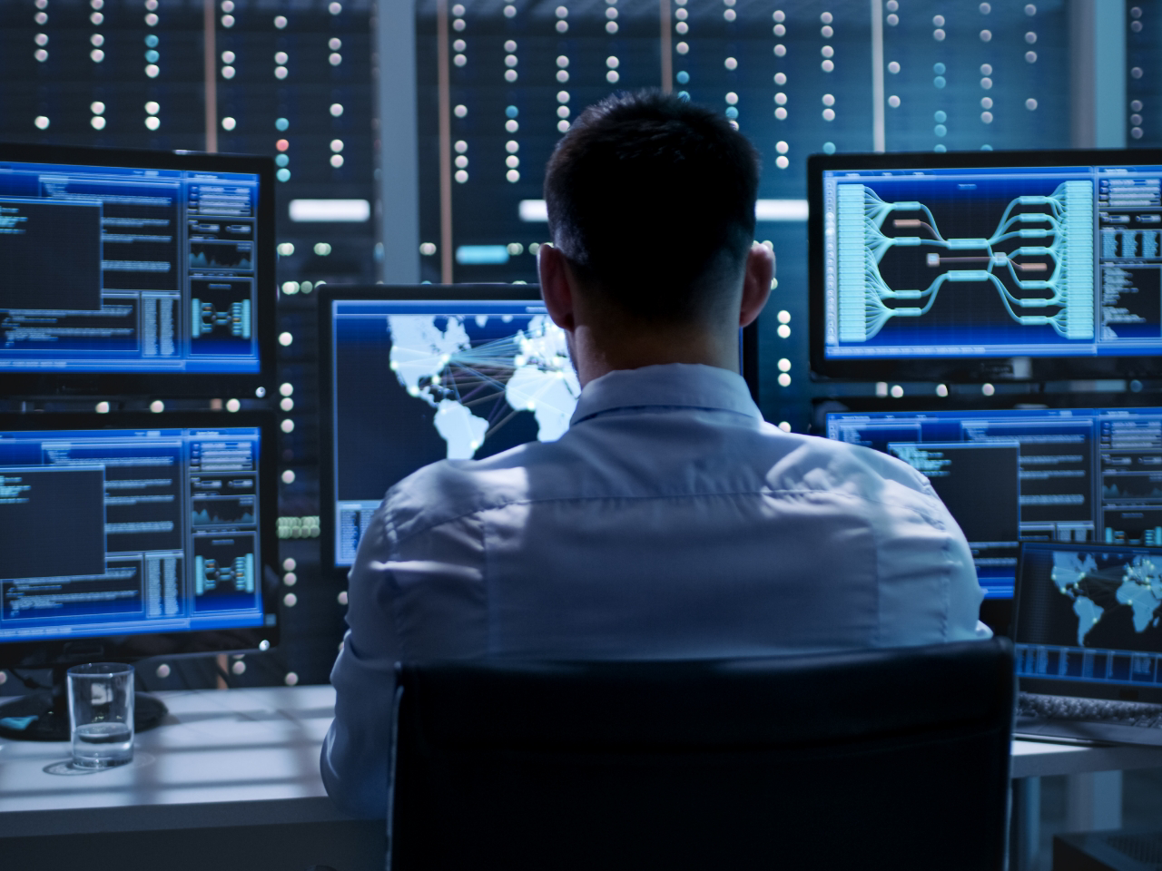 Man working in front of several screens