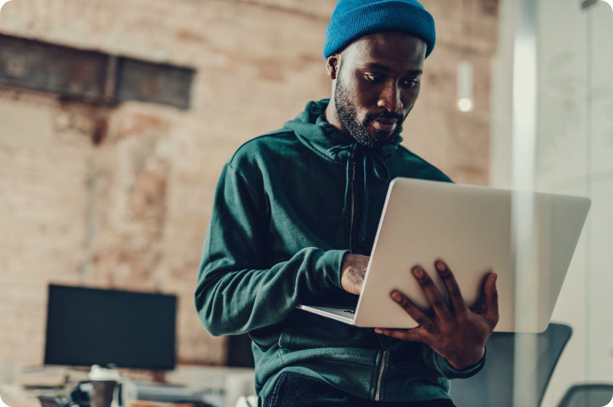 Egy férfi állva használja a laptopot