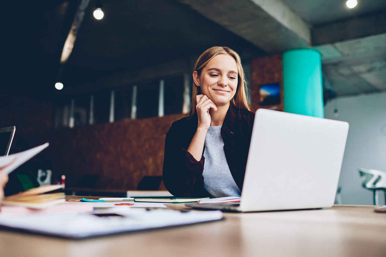 Vrouw die kijkt naar opleidings-webinar op laptop