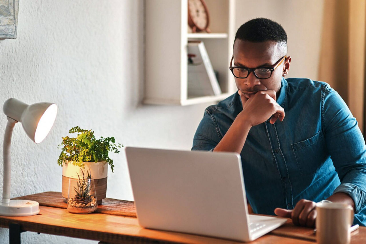 Young man in home office concentrated on laptop