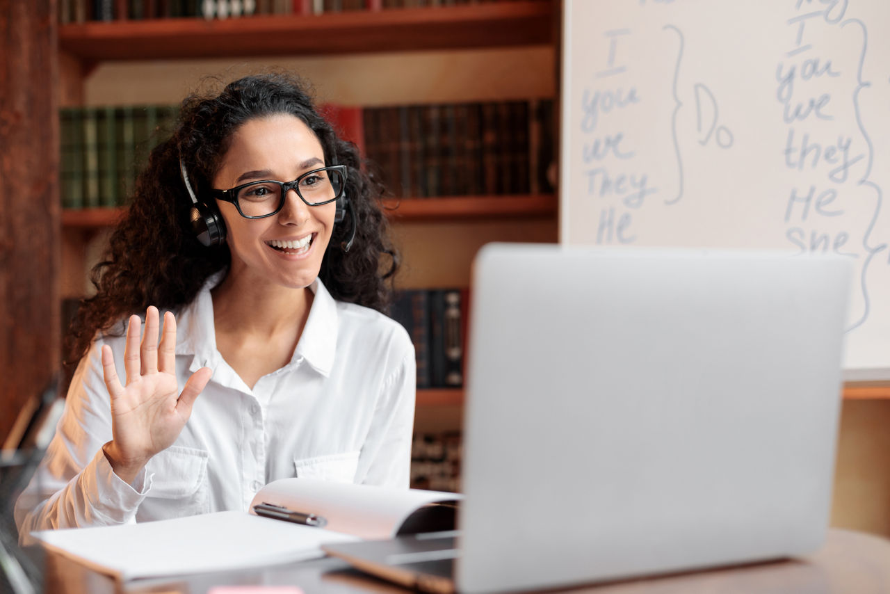 Donna che indossa occhiali e cuffie wireless durante una riunione virtuale