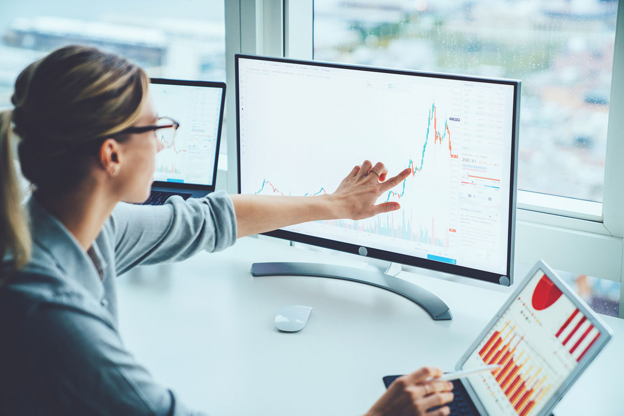 Mujer de negocios estudiando el mercado financiero para calcular posibles riesgos y ganancias