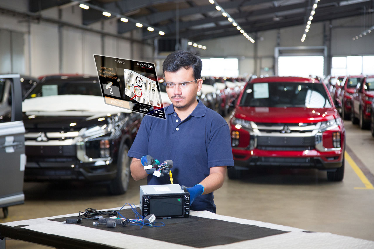 Werknemer in de automobielindustrie die slimme bril gebruikt waarop instructies getoond worden