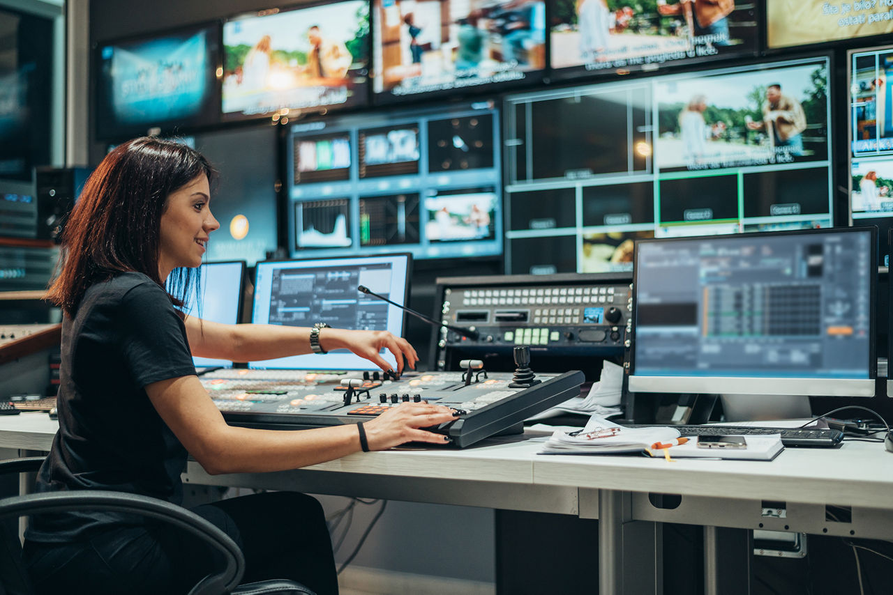 Woman working in a broadcast control room on a tv station