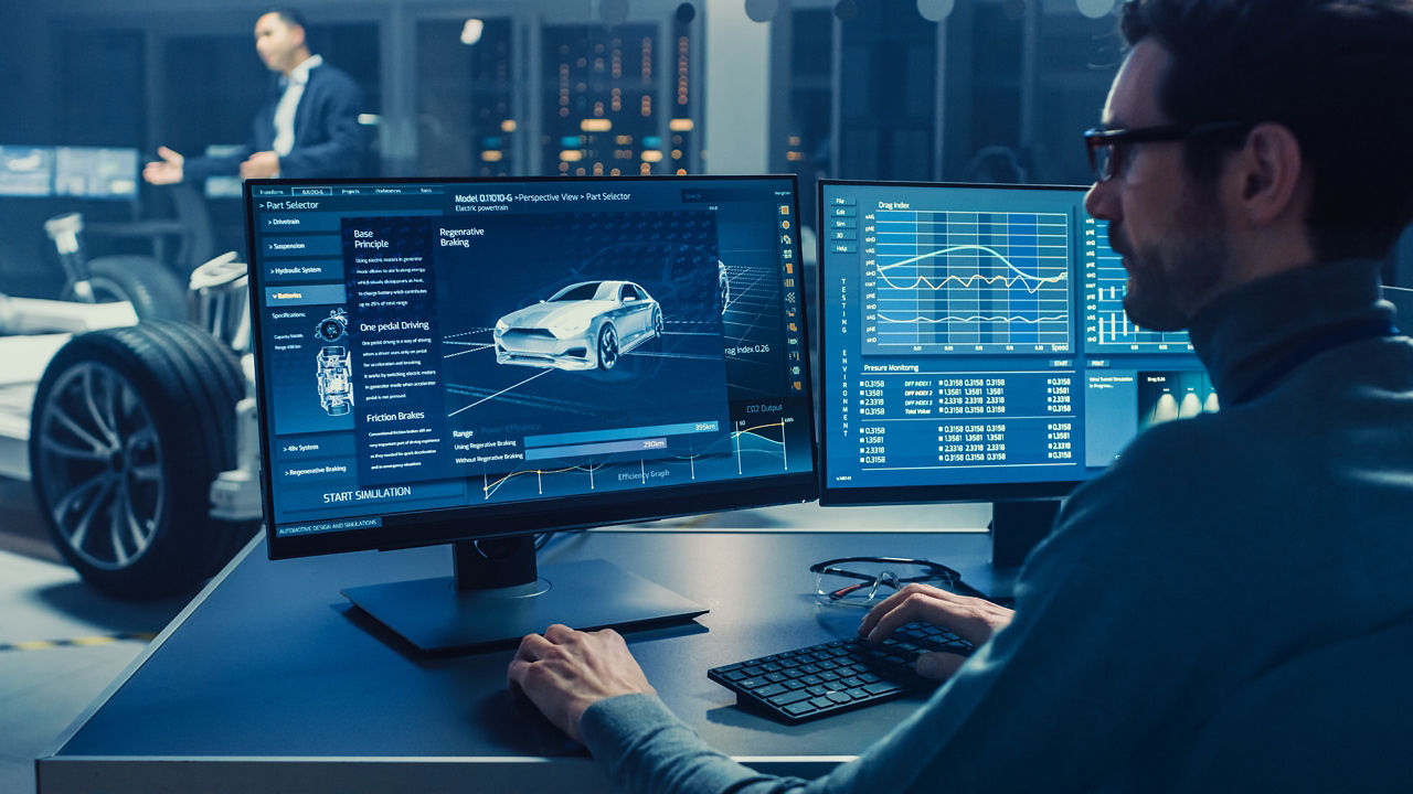 Ingénieur travaillant sur un ordinateur avec un logiciel de CAO 3D pour tester un prototype de châssis de voiture électrique