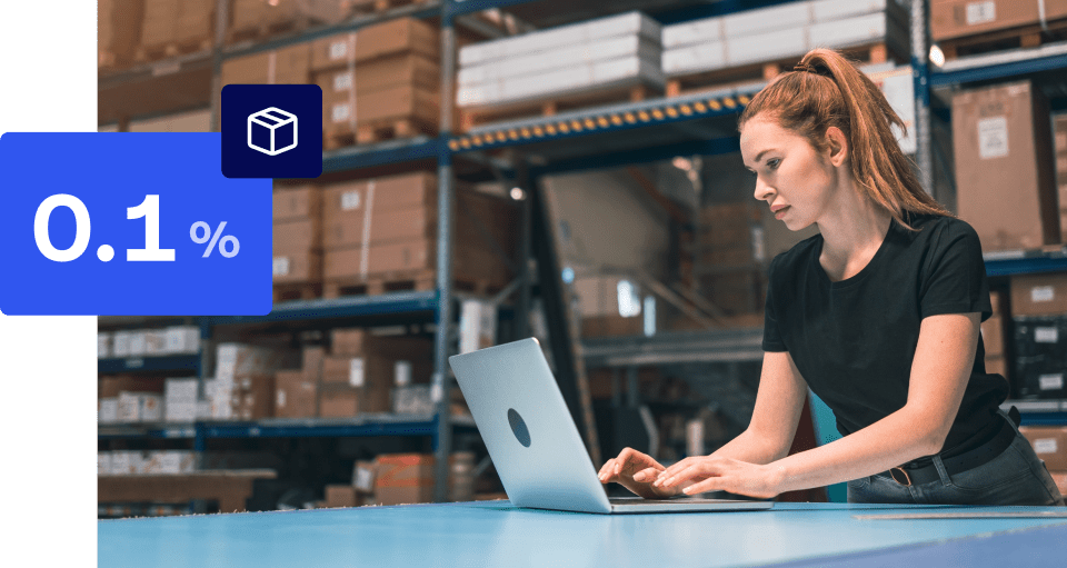 Woman in warehouse working on laptop